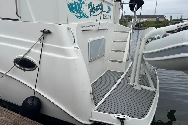 Slide: The Image of 2002 Silverton 352 Motor Yacht with dinghy on davit at dockside. - 8