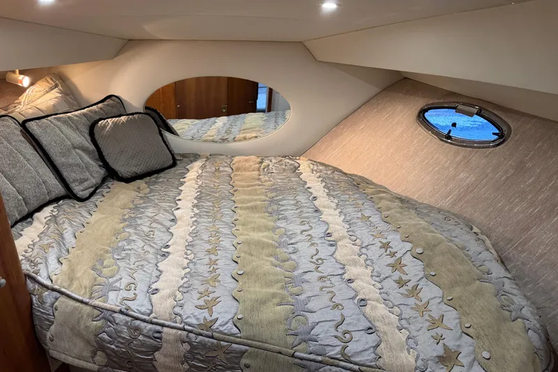 Slide: The Image of Cozy bedroom in 2002 Silverton 352 Motor Yacht with elegant bedding and porthole window. - 84