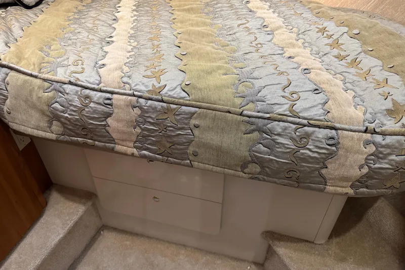 Slide: The Image of 2002 Silverton 352 Motor Yacht interior with patterned bedspread and storage drawers. - 85