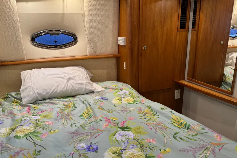 Slide: The Image of Cozy bedroom in 2002 Silverton 352 Motor Yacht with floral bedding and wooden cabinetry. - 92