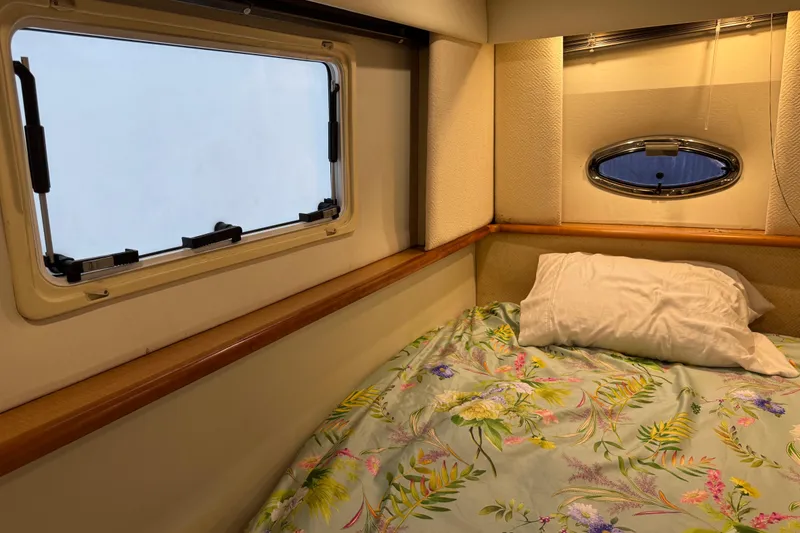 Slide: The Image of Cozy cabin interior of 2002 Silverton 352 Motor Yacht with floral bedding and porthole windows. - 93