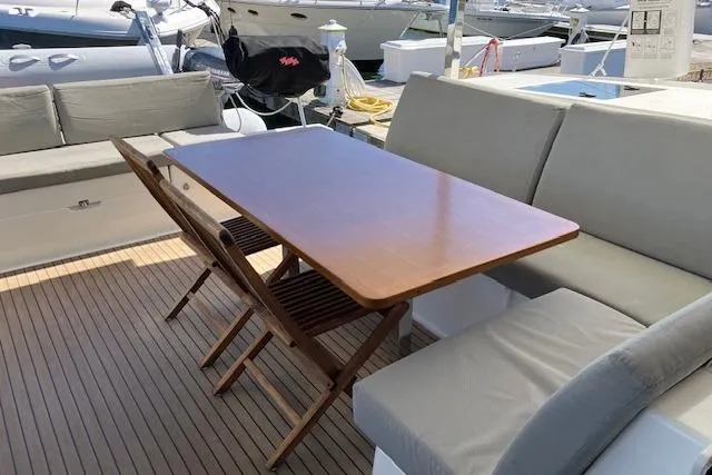 Slide: The Image of Outdoor seating area on 2021 Fountaine Pajot Isla 40 catamaran with wooden table and cushioned benches. - 17