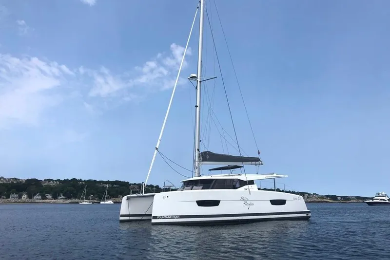 Slide: The Image of 2021 Fountaine Pajot Isla 40 catamaran sailing on calm waters under a clear blue sky. - 2
