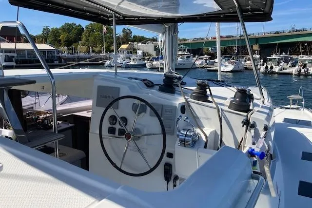 Slide: The Image of 2021 Fountaine Pajot Isla 40 catamaran helm with marina backdrop. - 25