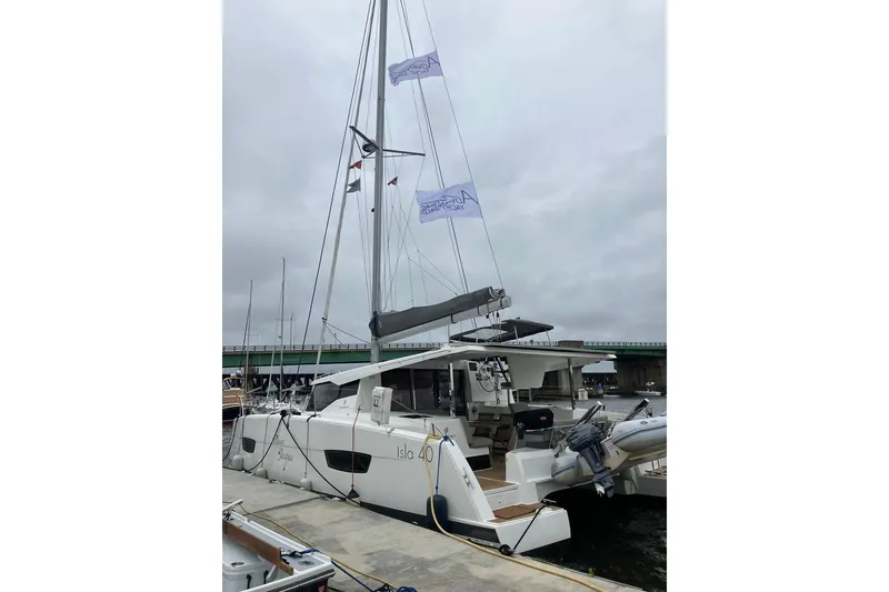 Slide: The Image of 2021 Fountaine Pajot Isla 40 catamaran docked at a marina under cloudy skies. - 3