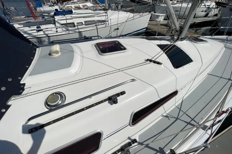 Slide: The Image of 2004 Hunter 33-2 sailboat deck with hatches and rigging in marina setting. - 11
