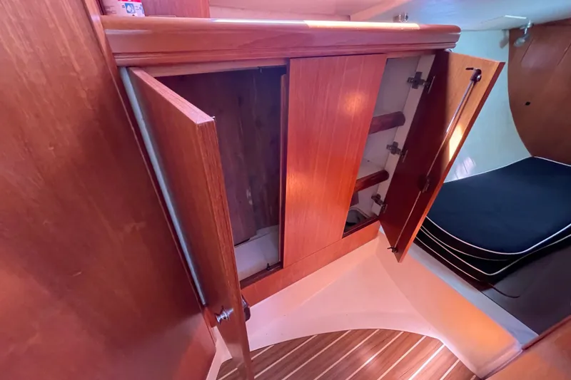 Slide: The Image of Interior of 2004 Hunter 33-2 sailboat showing wooden cabinetry and sleeping area. - 27