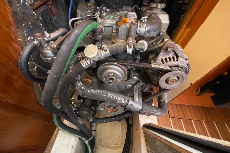 Slide: The Image of 2004 Hunter 33-2 engine with visible belts and hoses in a wooden compartment. - 28