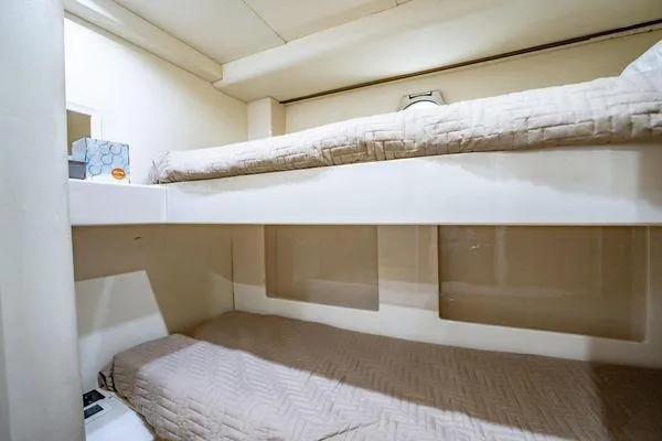 Slide: The Image of Bunk beds in 2003 Azimut 80 Carat yacht cabin, featuring beige bedding and compact design. - 12
