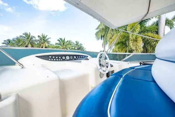 Slide: The Image of Cockpit of 2003 Azimut 80 Carat yacht with blue seating and tropical backdrop. - 56