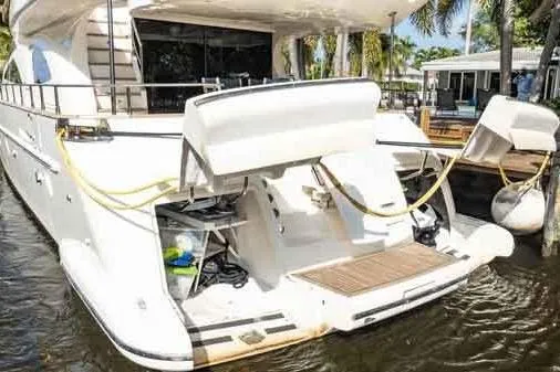 Slide: The Image of 2003 Azimut 80 Carat yacht docked, showcasing rear deck and storage compartments. - 74