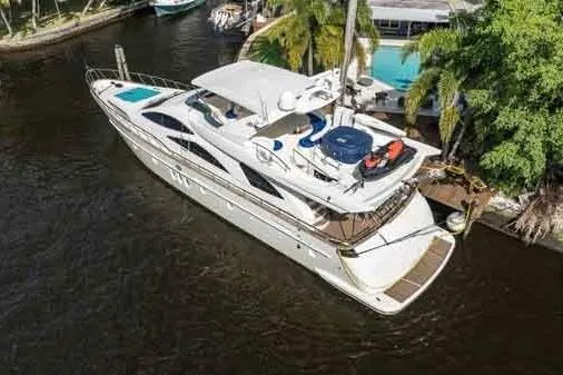 Slide: The Image of 2003 Azimut 80 Carat yacht docked near lush greenery and waterfront property. - 76