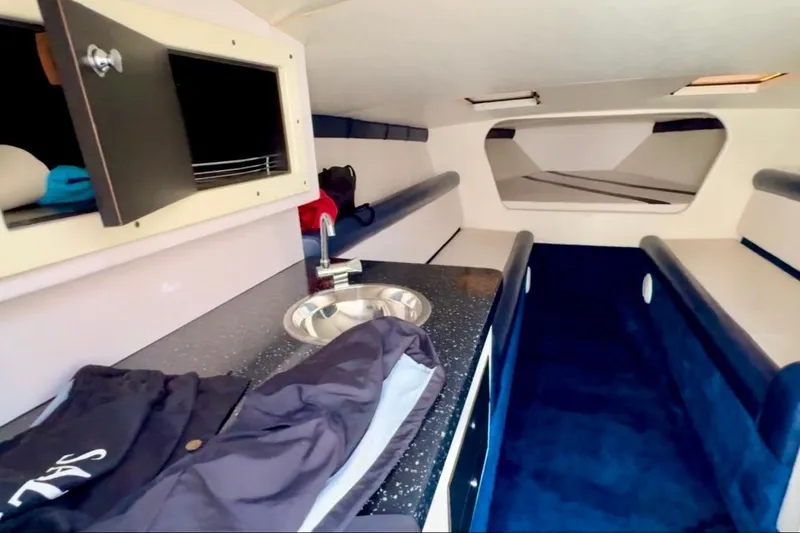 Slide: The Image of Interior of 2015 Donzi 38 ZR boat with kitchenette and seating area. - 10