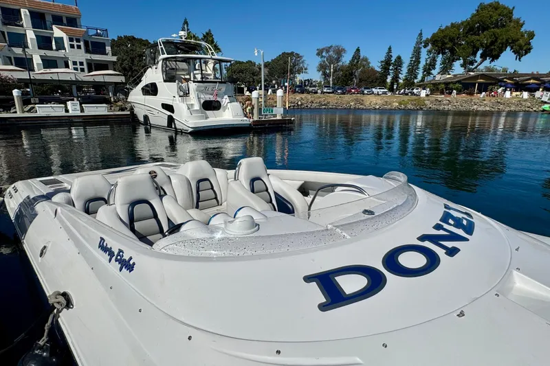 Slide: The Image of 2015 Donzi 38 ZR speedboat docked in a marina, with luxury yacht in background. - 2