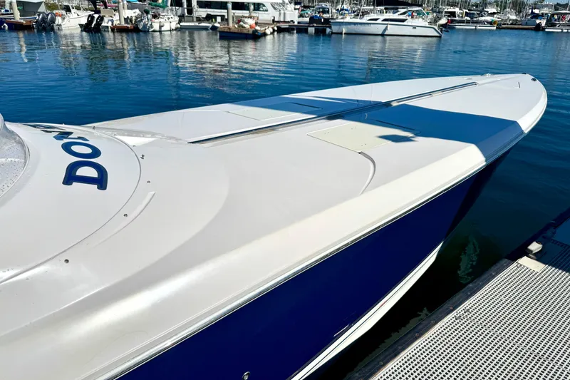 Slide: The Image of 2015 Donzi 38 ZR speedboat docked at a marina, showcasing sleek design and vibrant blue hull. - 3