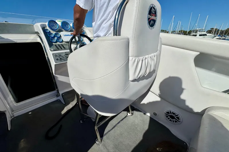 Slide: The Image of 2015 Donzi 38 ZR boat cockpit with steering wheel and gauges, featuring white seating. - 9