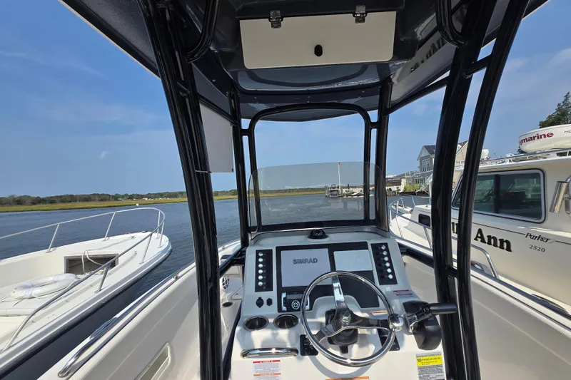 Slide: The Image of 2022 Robalo R222 Center Console boat interior with steering wheel and navigation system. - 16