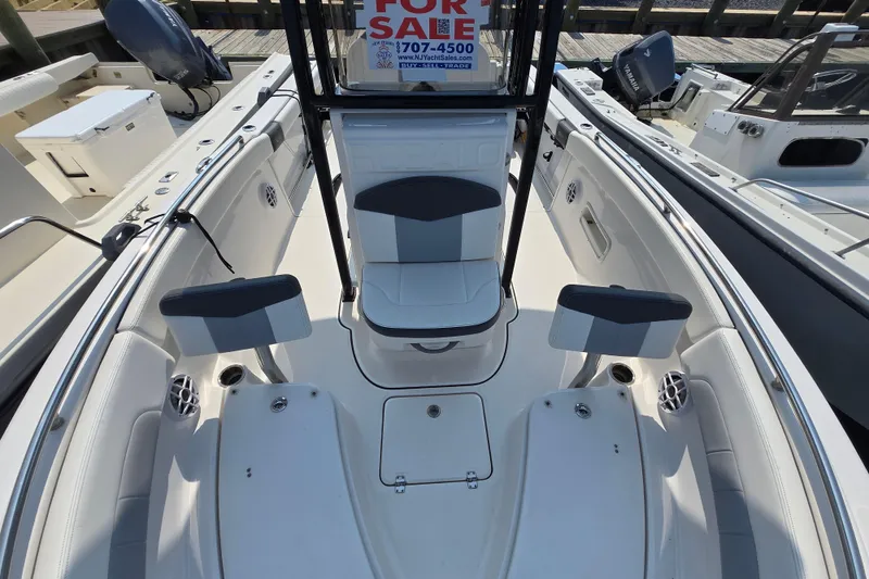 Slide: The Image of 2022 Robalo R222 Center Console boat interior with seating, for sale sign visible. - 2