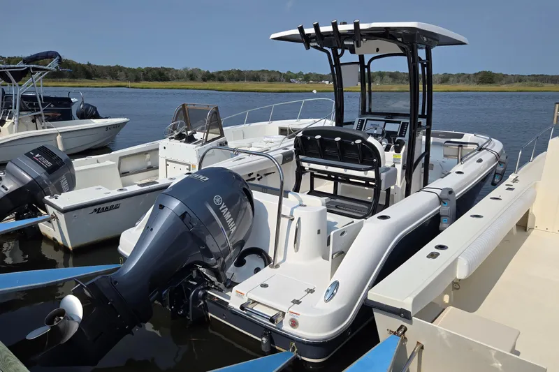 Slide: The Image of 2022 Robalo R222 Center Console boat with Yamaha engine docked by the water. - 21