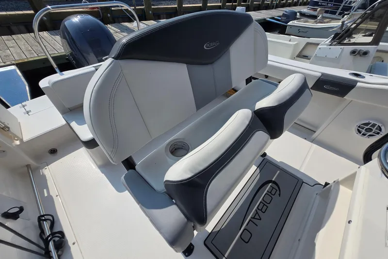 Slide: The Image of 2022 Robalo R222 Center Console boat seating area with cushioned seats and console details. - 24