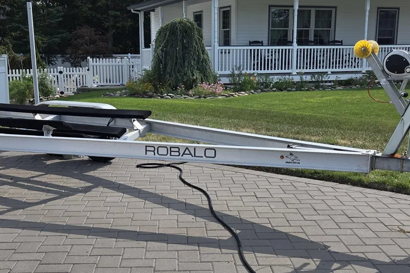 Slide: The Image of Trailer for 2022 Robalo R222 Center Console boat on paved driveway. - 28