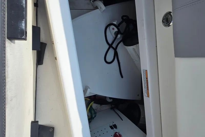 Slide: The Image of Storage compartment of a 2022 Robalo R222 Center Console boat, featuring equipment and accessories. - 29