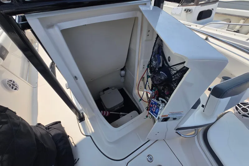 Slide: The Image of 2022 Robalo R222 Center Console boat storage compartment with wiring and equipment. - 8