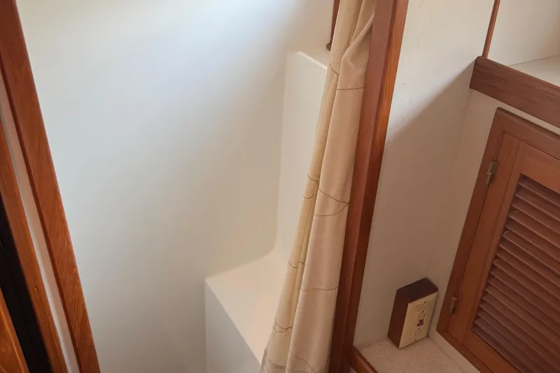 Slide: The Image of 1998 Kadey-Krogen 48' Northsea Pilothouse bathroom with wooden accents and shower curtain. - 29