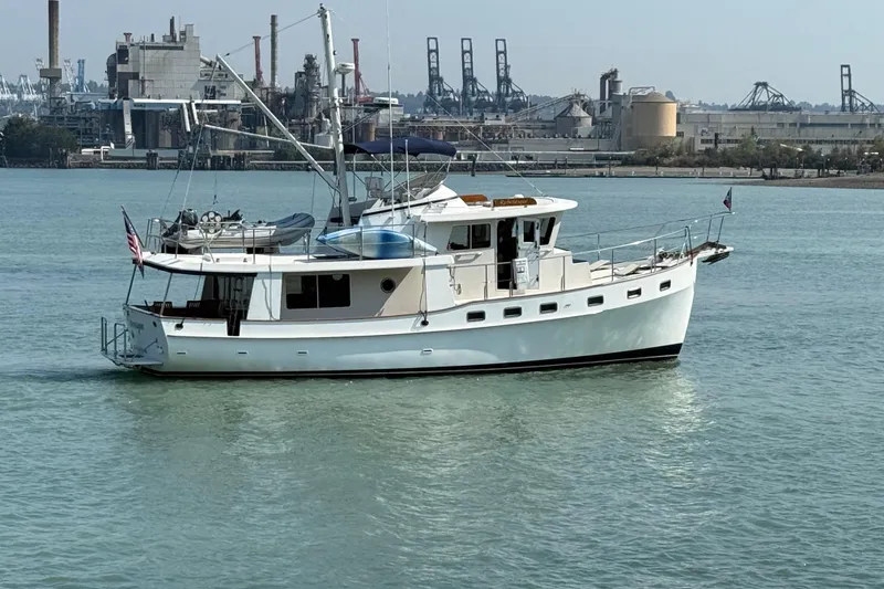 Slide: The Image of 1998 Kadey-Krogen 48' Northsea Widebody Pilothouse yacht on calm waters near industrial backdrop. - 41