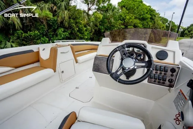Slide: The Image of 2022 Starcraft SVX 191 OB boat interior with modern steering and seating, surrounded by lush greenery. - 5