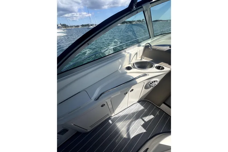 Slide: The Image of 2002 Sea Ray 340 Sundancer interior with sink, cup holders, and scenic water view. - 8