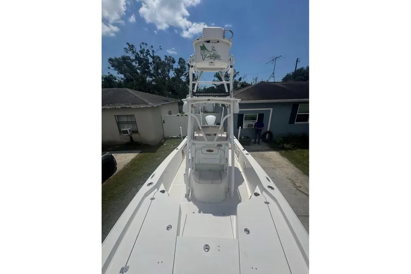 Slide: The Image of 2016 Sea Hunt BX 24 BR boat with elevated tower, parked in residential driveway. - 10