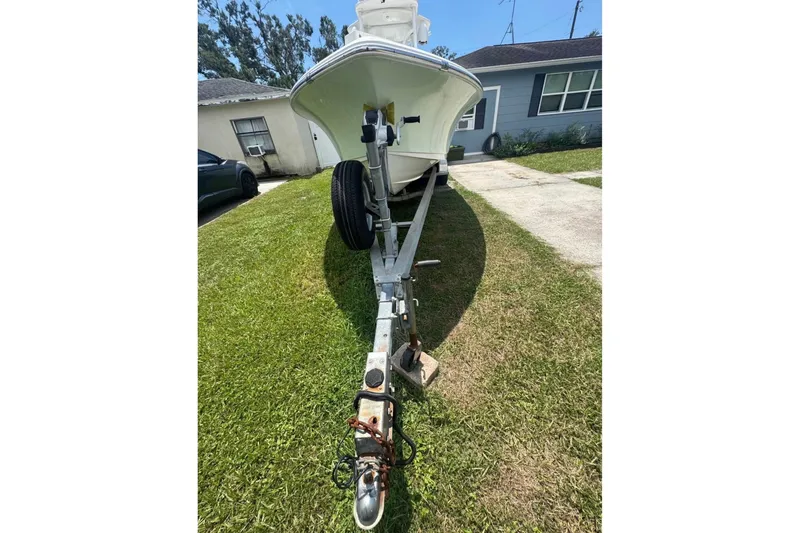 Slide: The Image of 2016 Sea Hunt BX 24 BR boat on trailer, parked on grass beside a house. - 15
