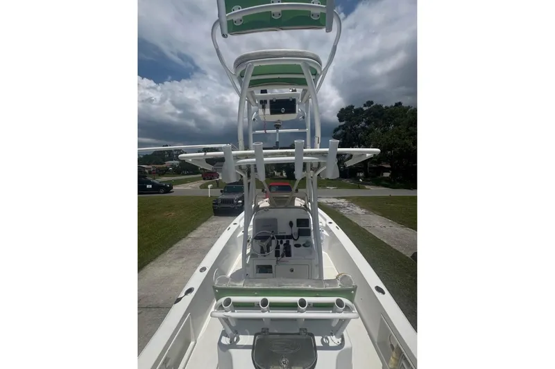 Slide: The Image of 2016 Sea Hunt BX 24 BR boat with T-top and rod holders, parked outdoors. - 4