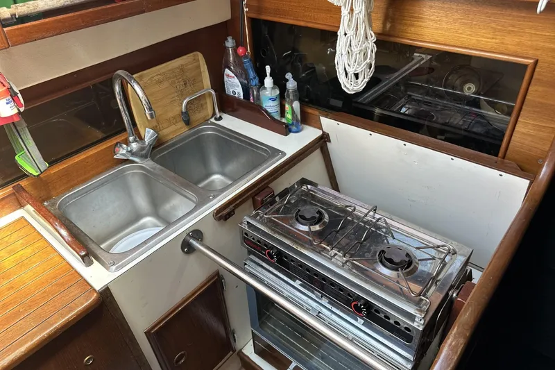 Slide: The Image of 1982 Cape Dory 30 yacht kitchen with dual sink and two-burner stove. - 13