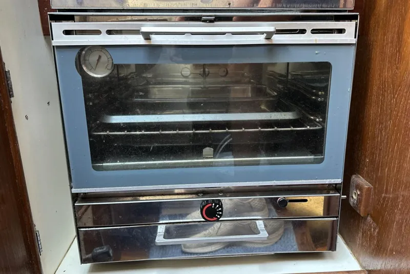 Slide: The Image of Vintage oven inside a 1982 Cape Dory 30 sailboat, featuring a temperature gauge and control knob. - 14