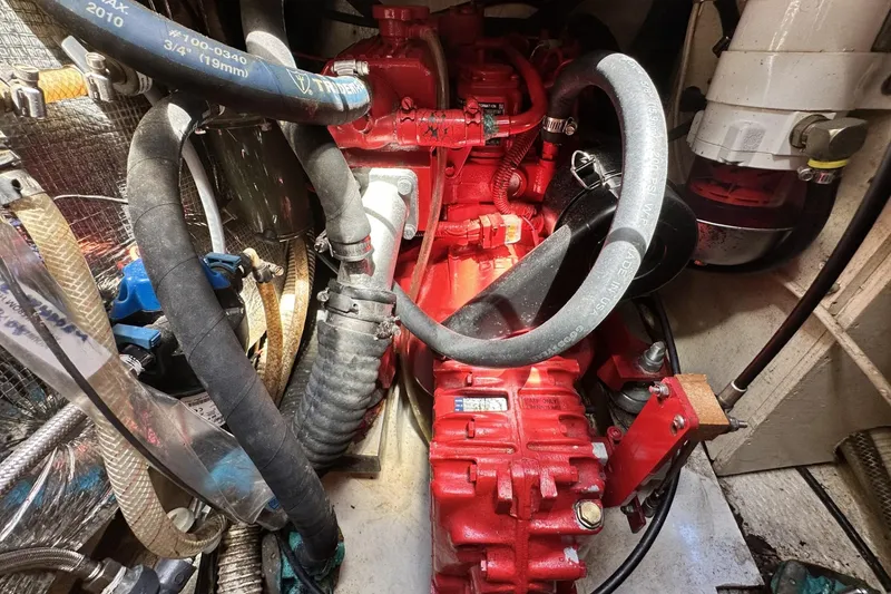 Slide: The Image of Engine compartment of a 1982 Cape Dory 30 sailboat, featuring red engine and hoses. - 17