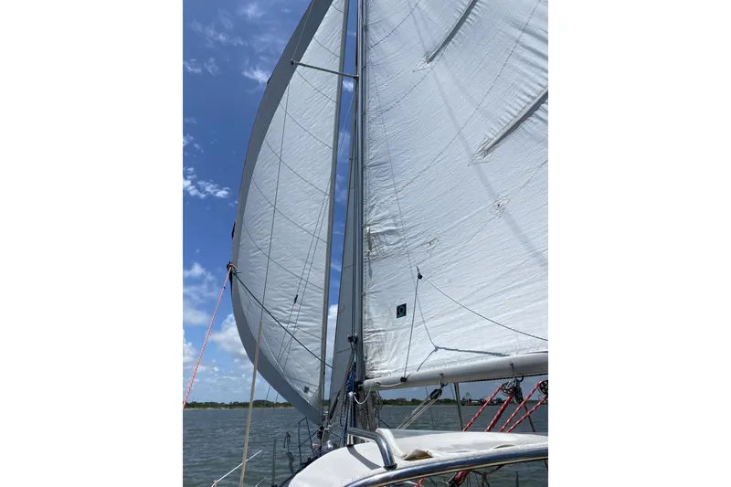 Slide: The Image of Sailing on a 1982 Cape Dory 30 with white sails against a blue sky. - 22