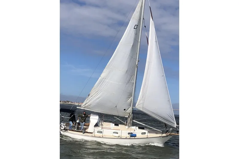 Slide: The Image of 1982 Cape Dory 30 sailboat navigating on open water under clear skies. - 23