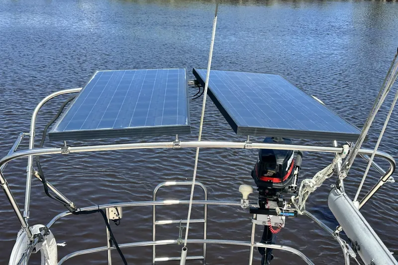 Slide: The Image of 1982 Cape Dory 30 sailboat with solar panels and motor on calm water. - 28