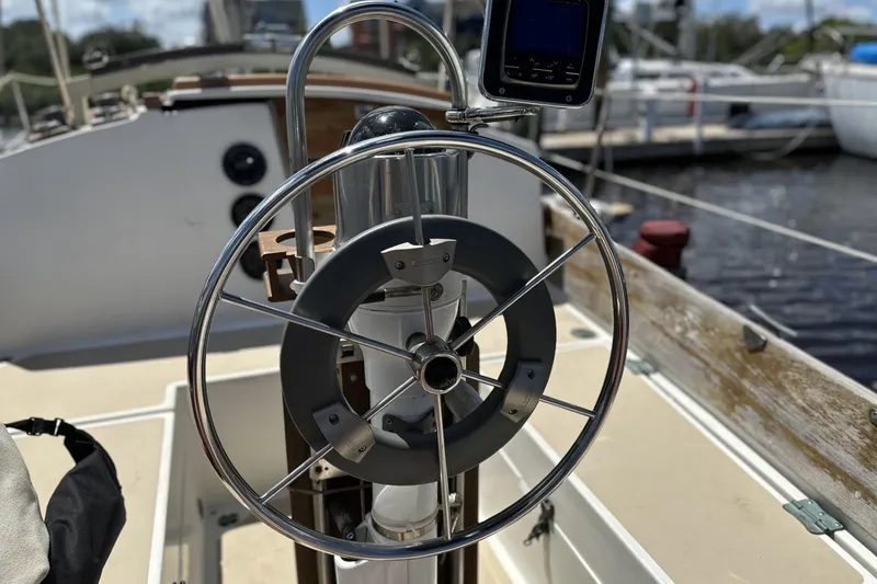 Slide: The Image of Steering wheel of a 1982 Cape Dory 30 sailboat, docked at a marina. - 35
