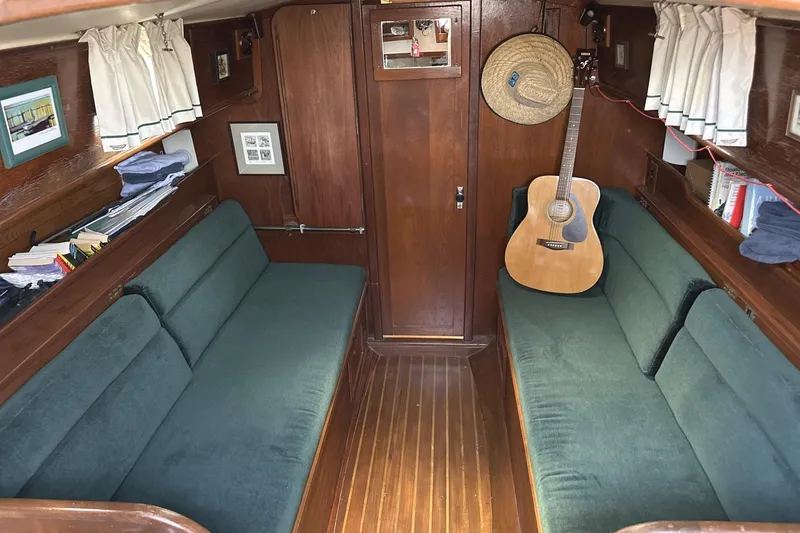 Slide: The Image of Interior of 1982 Cape Dory 30 sailboat with green seating and a guitar. - 8