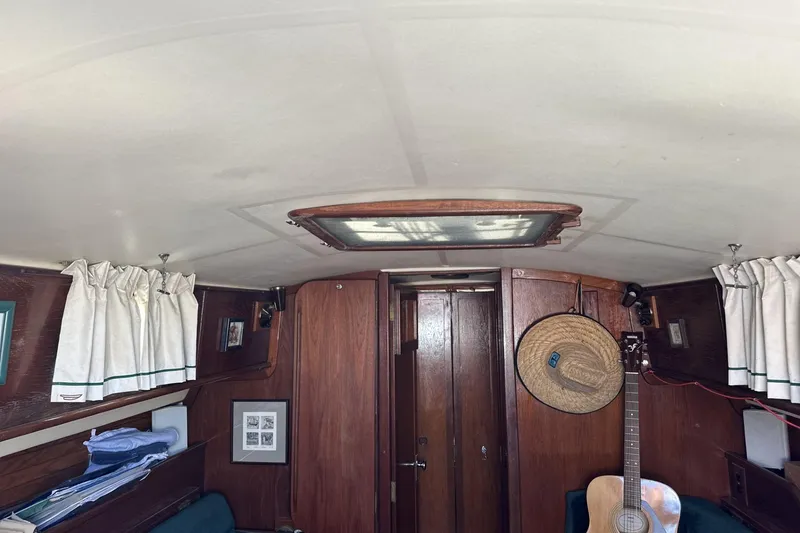 Slide: The Image of Interior of 1982 Cape Dory 30 sailboat with wood paneling and guitar. - 9