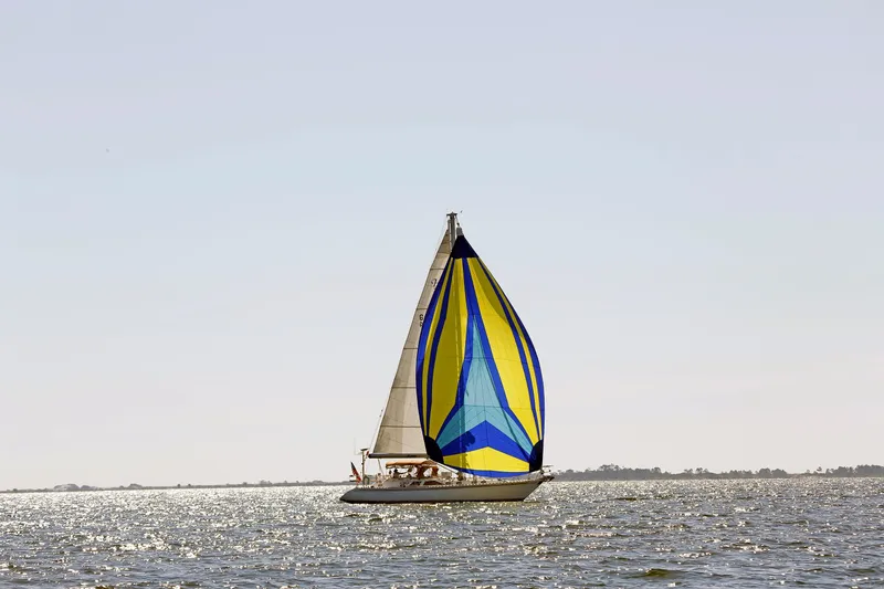 Slide: The Image of Sailboat Hylas 49CC 2012 with colorful spinnaker on shimmering water. - 10