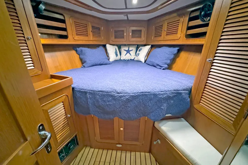 Slide: The Image of Cozy cabin interior of 2012 Hylas 49CC yacht with blue bedding and wooden finish. - 107