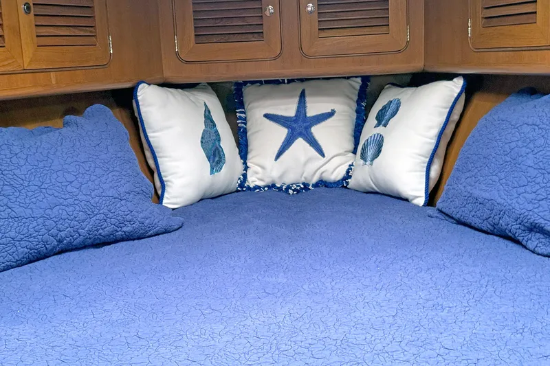 Slide: The Image of Cozy cabin bed with blue quilt and nautical-themed pillows in 2012 Hylas 49CC yacht. - 108