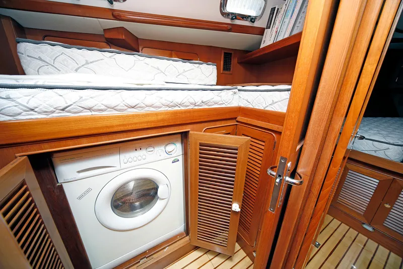 Slide: The Image of Cozy cabin interior of 2012 Hylas 49CC yacht with washer and wooden furnishings. - 111