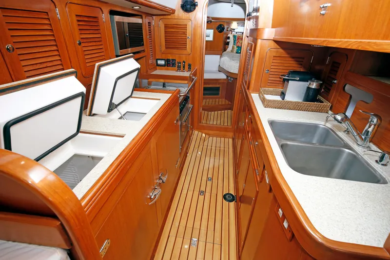 Slide: The Image of Luxurious 2012 Hylas 49CC yacht interior with wooden cabinetry and modern kitchen amenities. - 120