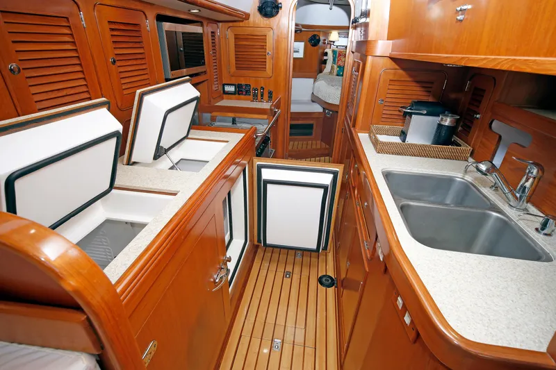 Slide: The Image of Luxurious 2012 Hylas 49CC yacht interior with wooden cabinetry and modern kitchen amenities. - 121