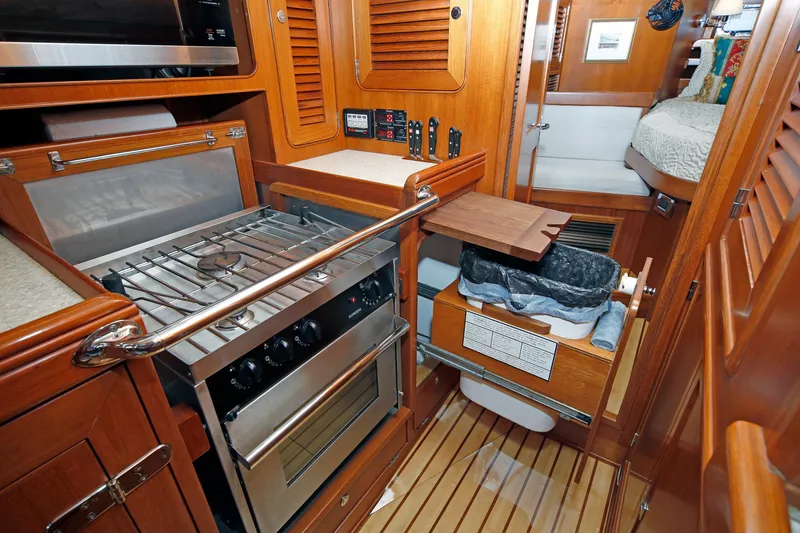 Slide: The Image of Compact kitchen area in a 2012 Hylas 49CC yacht with stove and storage. - 123